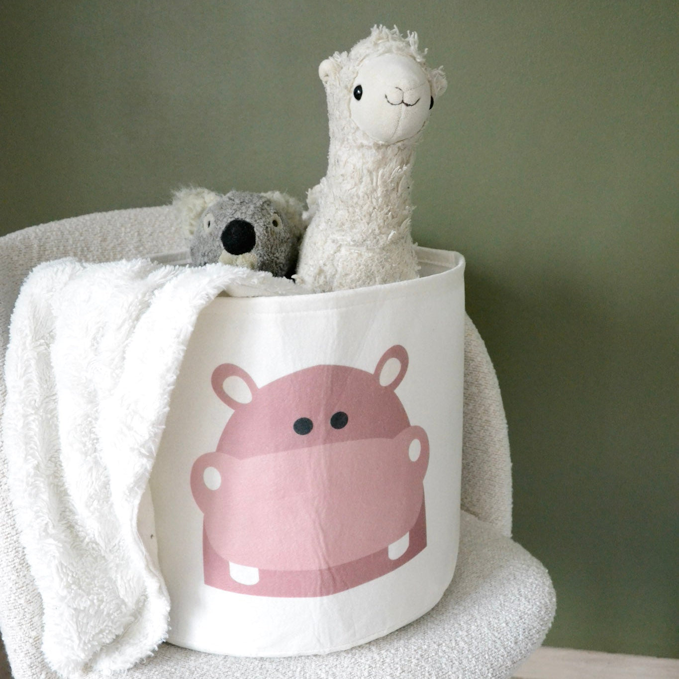 En stol med en kurv for oppbevaring av leker og kosedyr til barn, med flodhestmotiv