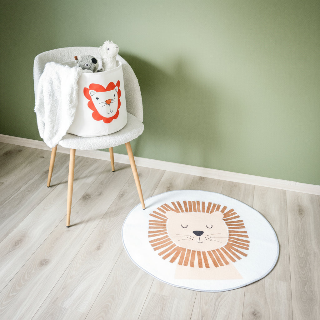 Et hvitt rundt teppe med løvemotiv, sammen med en stol med barneleker. 