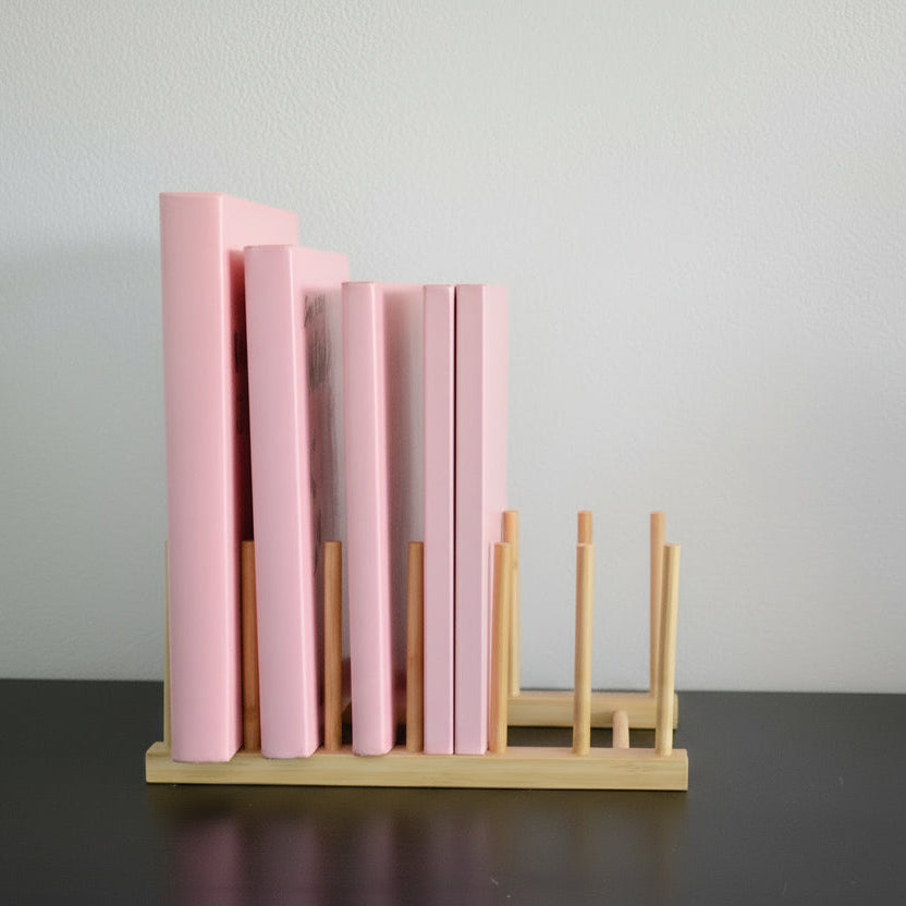 Bokholder i bambus med rosa bøker