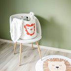 En stol med en kurv for oppbevaring av leker og kosedyr til barn, med løvemotiv