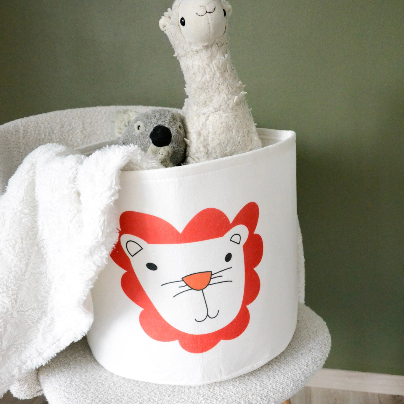 En stol med en kurv for oppbevaring av leker og kosedyr til barn, med løvemotiv